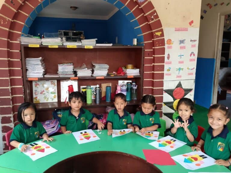 Bambini della scuola Baal Shikshya Udhyan di Bhaktapur, in Nepal, partecipano a un laboratorio creativo di ispirazione montessoriana in un'aula colorata.