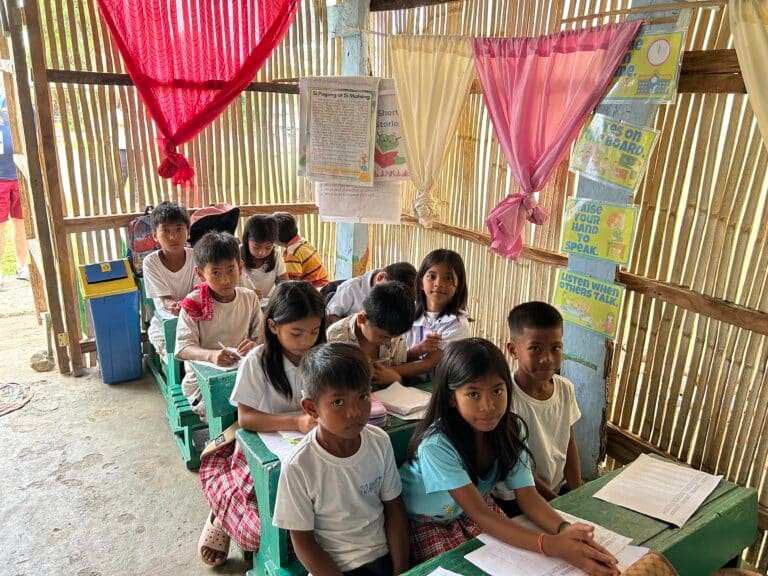 Salle de classe vétuste au Népal, avec bancs abîmés et sol en terre battue