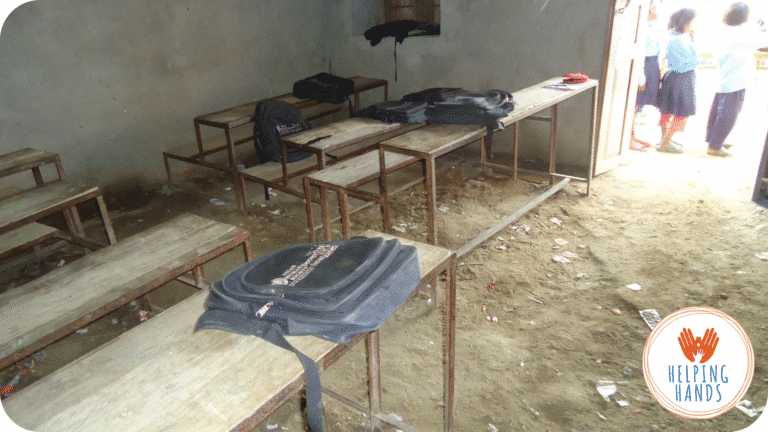 Salle de classe vétuste au Népal, avec bancs abîmés et sol en terre battue