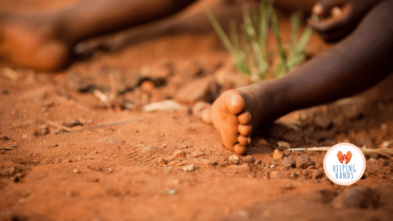 Pieds nus d'enfants assis au sol dans un village des Philippines – besoin urgent de chaussures enfants Philippines