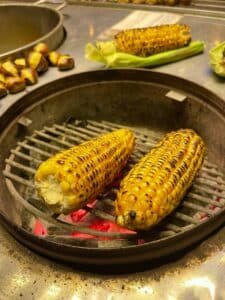 Épis de maïs grillés vendus par un migrant dans le métro, symbole des héros invisibles du quotidien