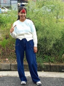 Roja à Katmandou, souriante, portant le tika rouge de Dashain sur le front – symbole de bénédiction et de réussite scolaire au Népal.